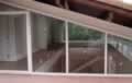 Vista externa de conjunto de persianas de enrolar entre-abertas em residência de alto padrào em codomínio fechado em Alphaville.